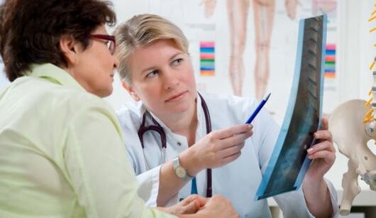 un médico examina unha radiografía para detectar dores nas costas